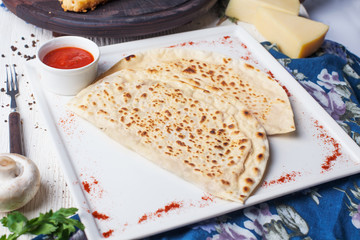 Flat lavash, flat khachapuri on a plate, still life restaurant sauce