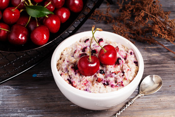 oatmeal porridge with cherry still life on a black background breakfast, cereal,
