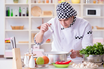 Young male cook working in the kitchen