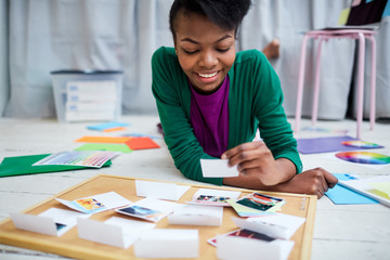 Girl lying on the floor of design-studio and looking through photos