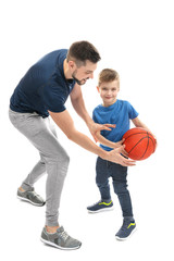 Handsome man and his son playing basketball on white background