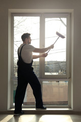 Fototapeta premium Young man washing window in office
