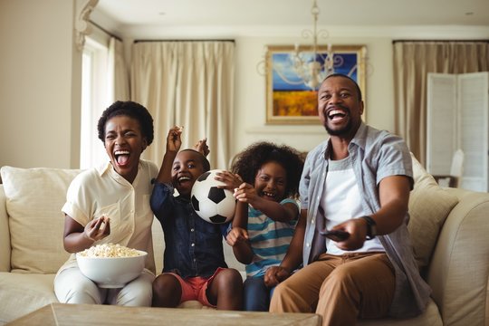 Parents And Kids Having Fun In Living Room