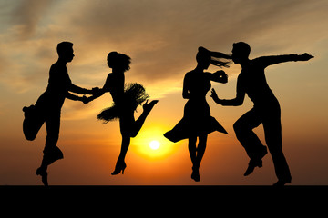 Silhouette couple in the active ballroom dance on sunset