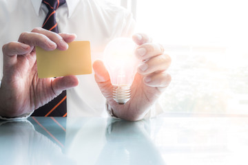 Businessman holding credit card and Light bulb © nithid18