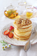 Pancakes with strawberries, caramel cream, walnuts and mint tea