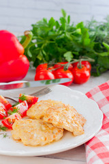 Chicken cutlets chopped with tomatoes on a white plate, selective focus