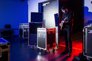 Roadie playing guitar backstage - obrazy, fototapety, plakaty