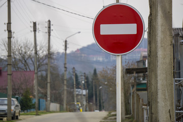 Round red road sign on metal pole. No Entry road-sign mounted on urban roadside