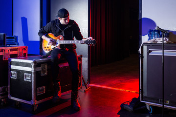Roadie tuning a guitar for the guitarist