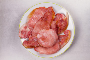 Bacon on white plate. Grilled rashers. View from above, top studio shot