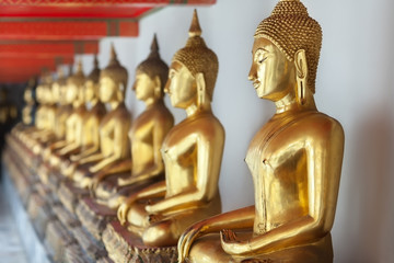 Row of golden buddha statues Bangkok