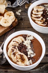 Chocolate smoothie bowl with banana, chia seeds and almond chips