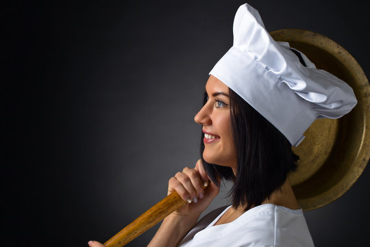 young woman in chef uniform with big pan
