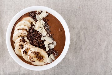 Chocolate smoothie bowl with banana, chia seeds and almond chips