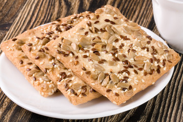 crispy bread with seeds of sunflower, flax and sesame seeds on a dark wooden background