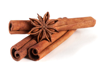 three cinnamon sticks with star anise isolated on white background
