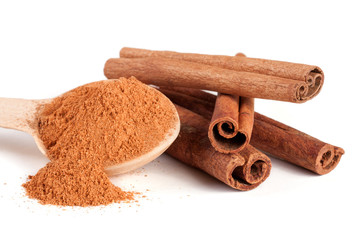 three cinnamon sticks and powder with spoon isolated on white background