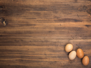 Easter eggs on old wooden table from planks. Top view with space for your design, Easter greetings or advertising. Rustic background.