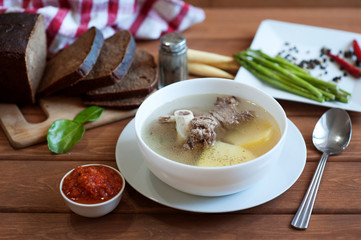 Soup with lamb meat and potato on restaurant table