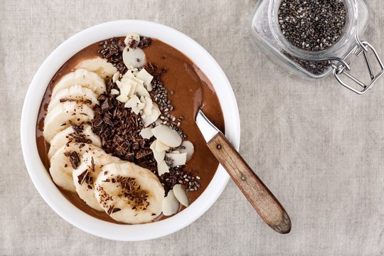 Chocolate smoothie bowl with banana, chia seeds and almond chips