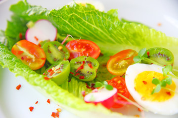 Cherry tomatoes and baby kiwis on romaine