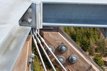 Wooden beams with screws in the structure. Assembling and connecting wooden beams. Detail of building connections. The construction of the observation tower.