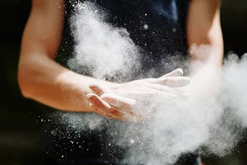 Tuinposter Climber woman coating her hands in powder chalk magnesium. Ready for climbing © olyphotostories
