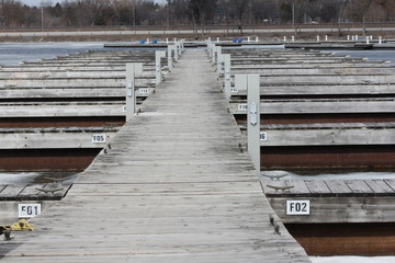 Fototapeta premium Empty boat slips during the early spring season in North America. Marina almost clear of ice. 
