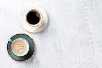 Türaufkleber Coffee cups on wooden kitchen table © karandaev