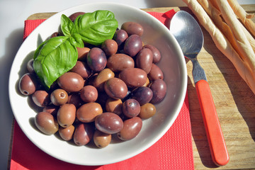 olive della riviera italiana  close-up di un piattino riempito con olive della riviera, pronte da gustare accompagnate da grissini caserecci