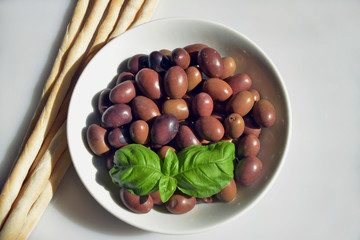 olive della riviera italiana  close-up di un piattino riempito con olive della riviera, pronte da gustare accompagnate da grissini caserecci