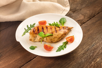 Grilled chicken fillet with cherry tomatoes and salad leaves