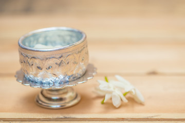 Obraz na płótnie Canvas Thailand Songkran festival decoration concept, water in silver bowl with jasmine white flower.