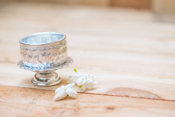 Thailand Songkran festival decoration concept, water in silver bowl with jasmine white flower.