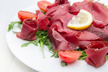 dish of bresaola and aragula