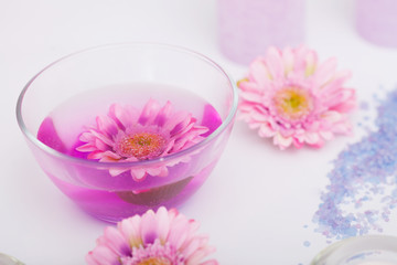 Spa Procedure. Woman In Beauty Salon Holding Fingers In Aroma Bath For Hands. Closeup Of Female Nails Soaking In Bowl Of Water With Pink Flower Petals. Aromatherapy. High Resolution