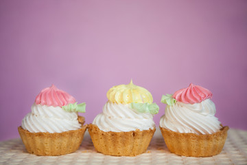 Three cakes on pink background with copy space