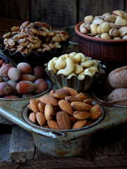 A composition from different varieties of nuts on a wooden background - almonds, cashews, walnuts, hazelnuts, pistachios.