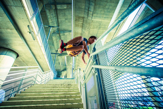 young man practice parkour jump in the city