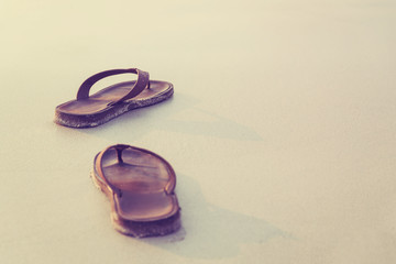 Abstract brown shoes on beach with sand background, vacation and holiday concept, with copy space