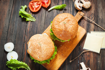 Two homemade beef burgers with egg on wood table