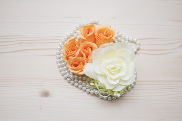 Roses flowers with pearls on a wood background