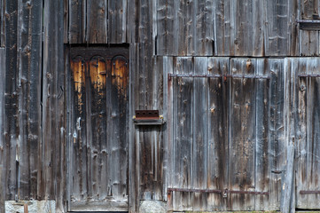 Weather worn wooden doors on wood panel building
