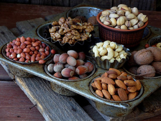 A composition from different varieties of nuts on a wooden background - almonds, cashews, peanuts, walnuts, hazelnuts, pistachios.