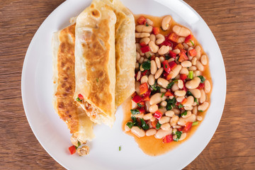 Mexican cuisine, burrito with garnish of beans