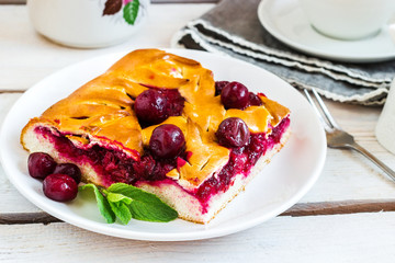 Cherry pie on white plate. Wooden background.