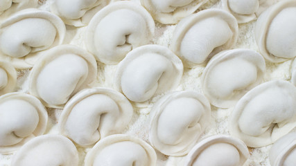 Uncooked dumplings on the table close-up