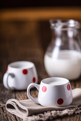 Milk. Cove or goat milk. Pouring milk into glass.
