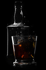 brandy or whiskey pouring into glass on a black background